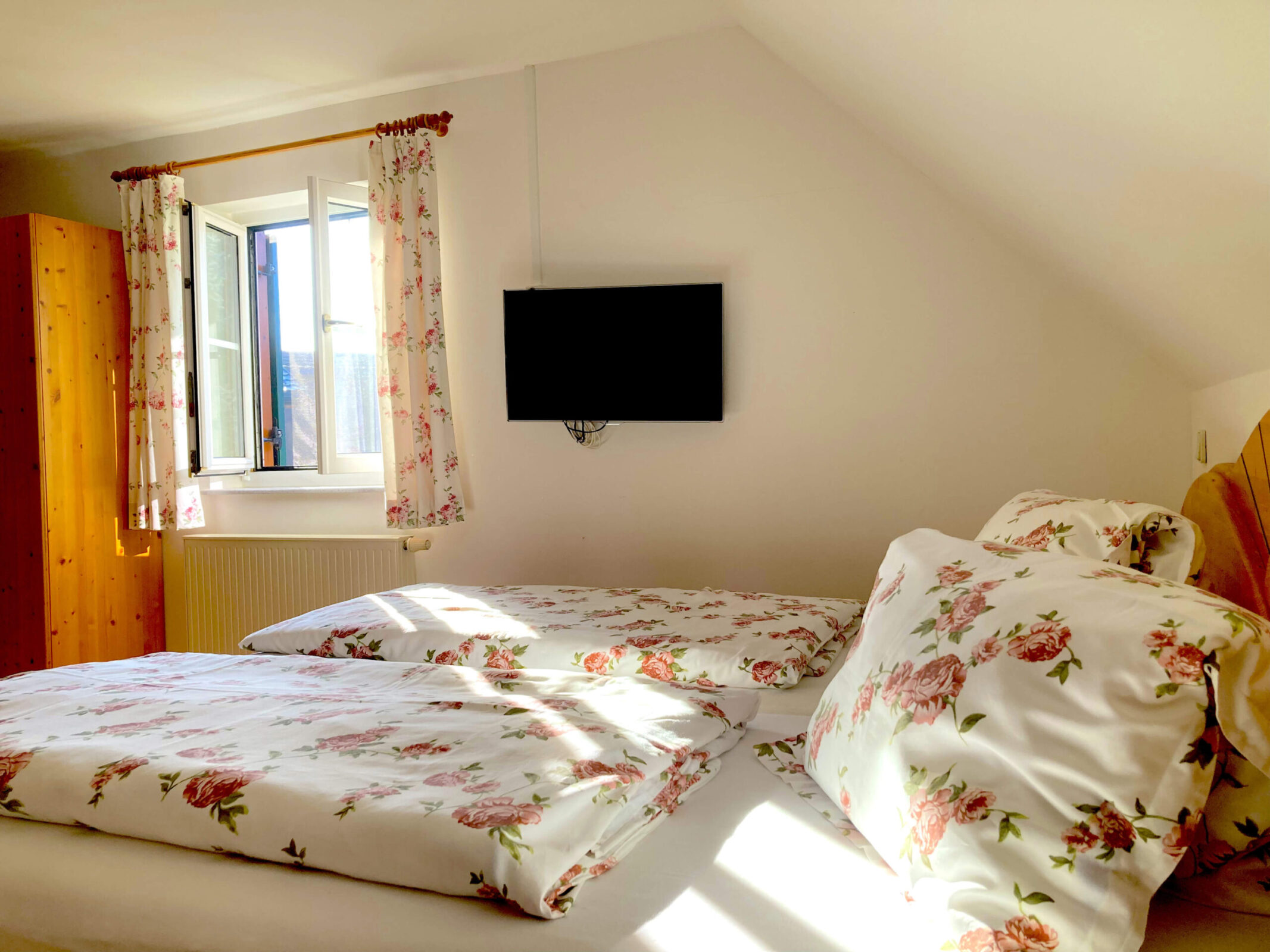 Schlafgalerie der Ferienwohnung Familienglück mit großem Doppelbett und gemütlicher Holzausstattung. Mit Verbindungstür in das zweite Schlafzimmer.