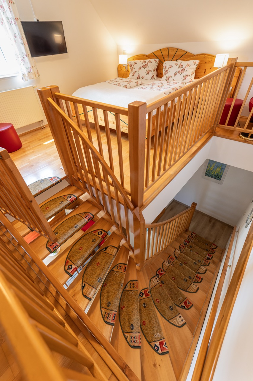 In das Schlafzimmer dieser schönen Wohnung führt eine bequeme breite Treppe mit Kindersicherheitstür beim Abgang.