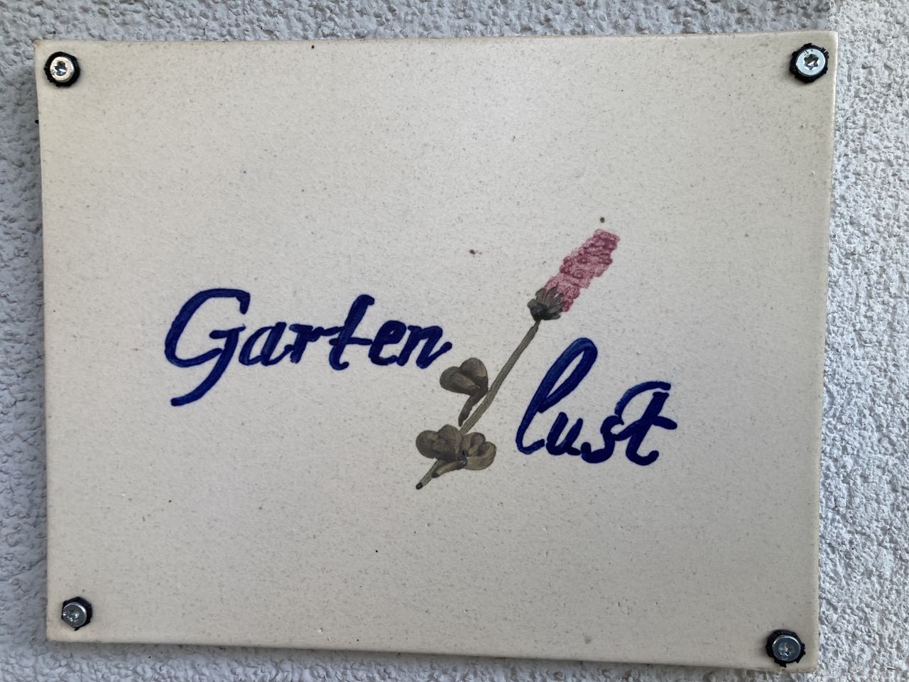 Freundliche Begrüßung mit einem Schild aus Keramik für die Wohnung Gartenlust