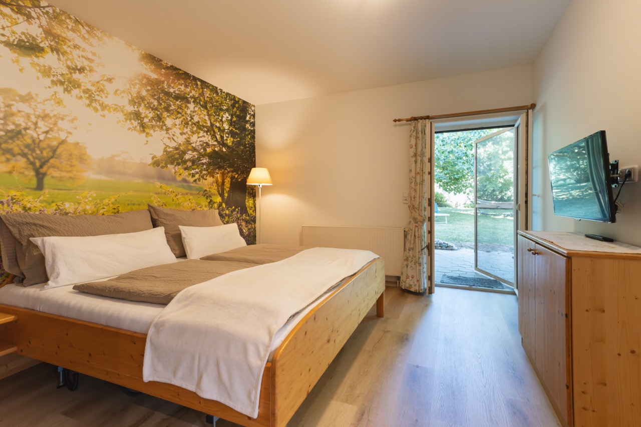 Wohnung mit großem Schlafzimmer mit ebenerdigen Zugang auf die private große überdachte Terrasse und in den Garten.