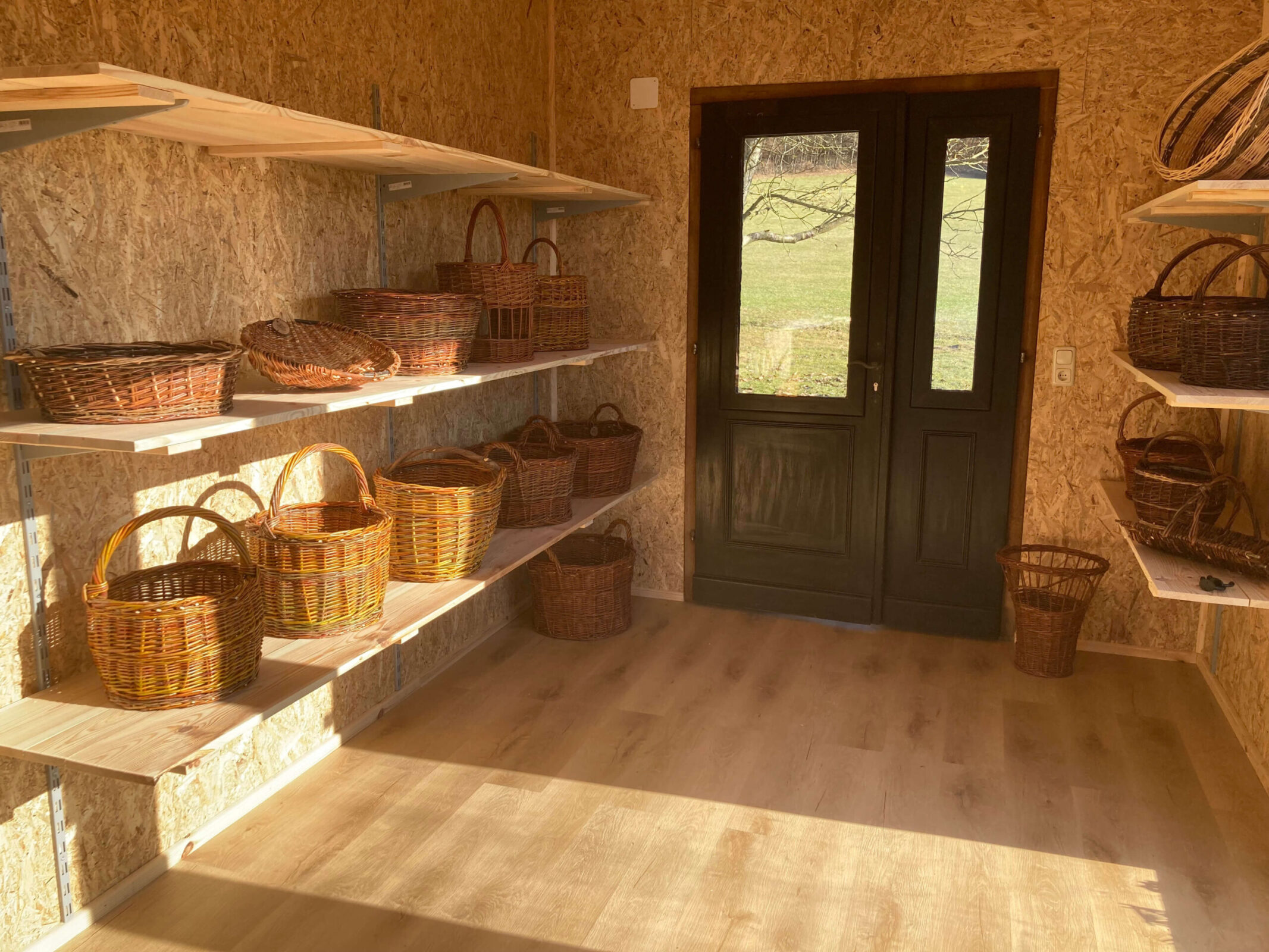 Urlaubsbauernhof Großer, sonniger Raum indem Weidenkörbe ausgestellt sind. Hofhandwerk im Landhaus Bender