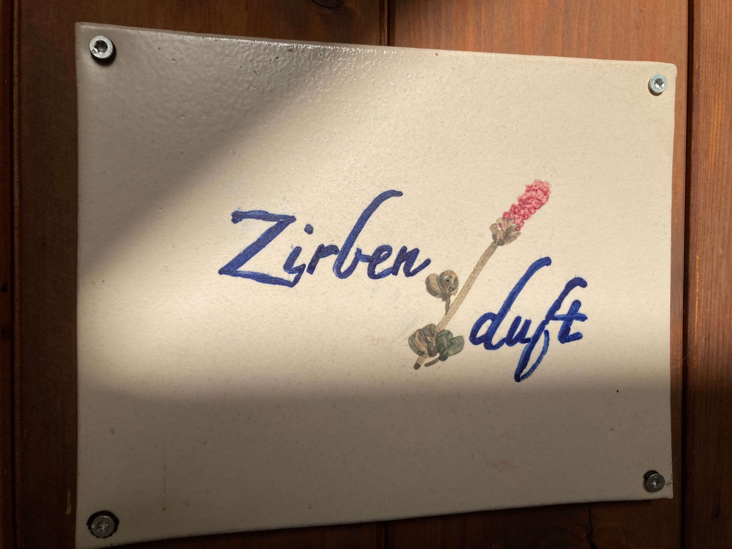 Eingangsschild aus Keramik mit dem Namen der Wohnung Zirbenduft. Freundliche Begrüßung
